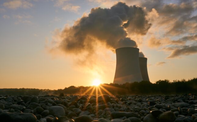 Wielkoskalowa farma fotowoltaiczna oraz kontenerowe magazyny energii BESS na tle nieba.